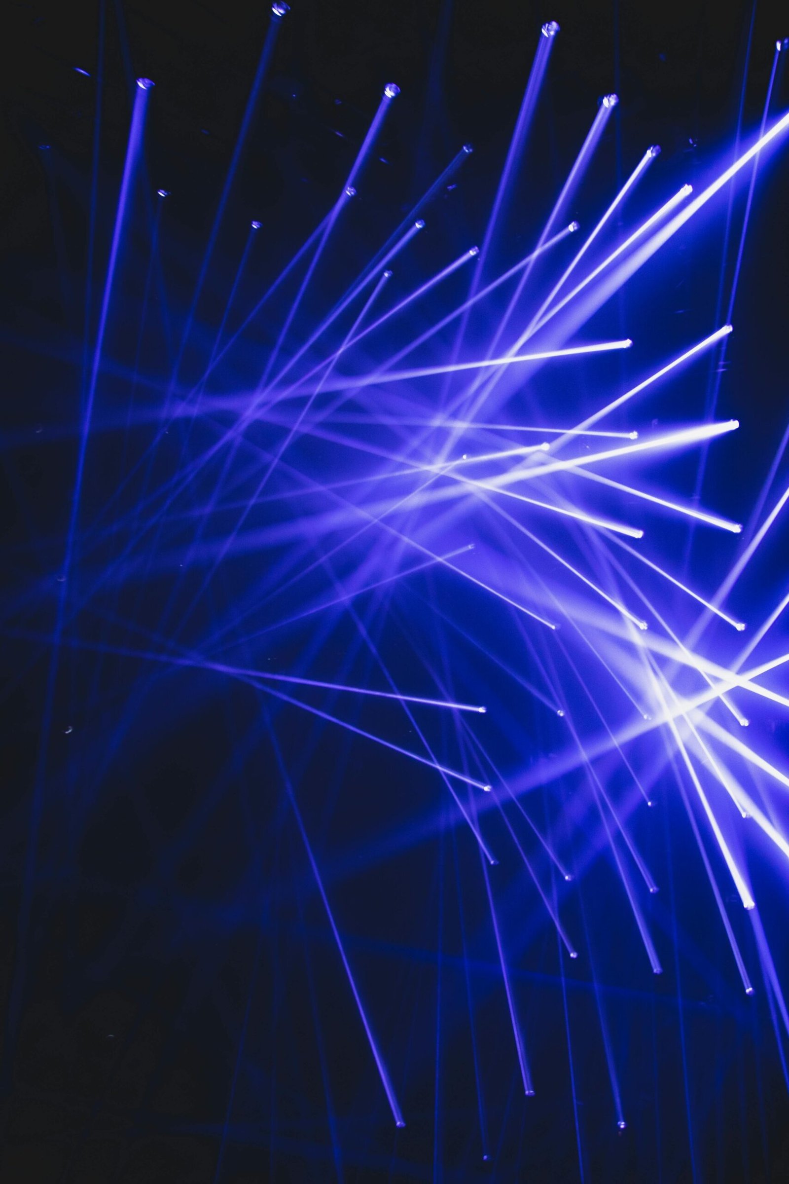 Dynamic blue laser lights create a vibrant and modern visual effect in a dark indoor setting.